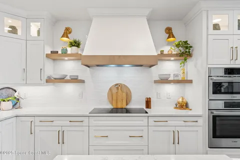 a kitchen with stainless steel appliances a sink a counter top space a large window and a view of living room