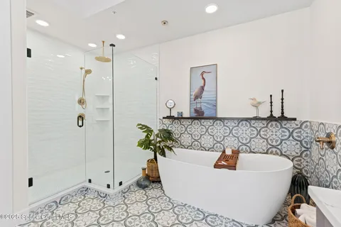 a bedroom with a bed a table a chair and potted plant on the dresser