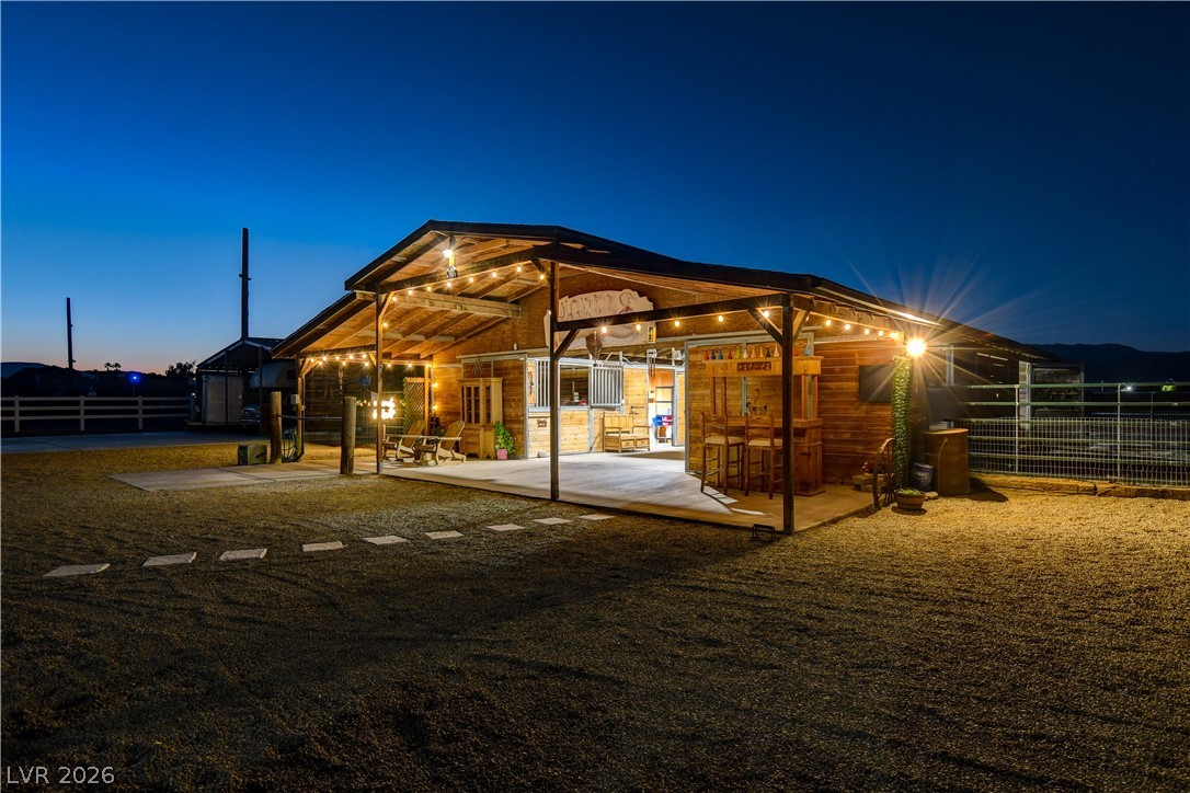 6460 Racel Street Las Vegas, NV 89131 - Photo 5 of 59 A spacious covered patio and outdoor bar extend from the rustic wooden barn structure.