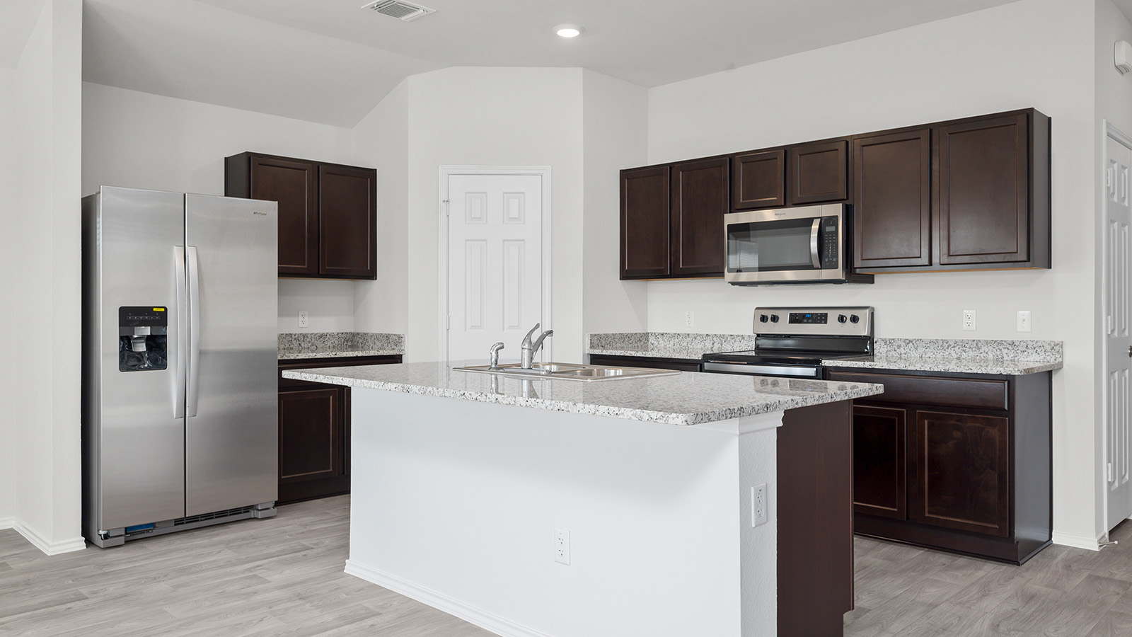 400 Timbo Drive Jarrell, TX 76537 - Photo 5 of 24 a kitchen with stainless steel appliances wooden cabinets a microwave and a refrigerator