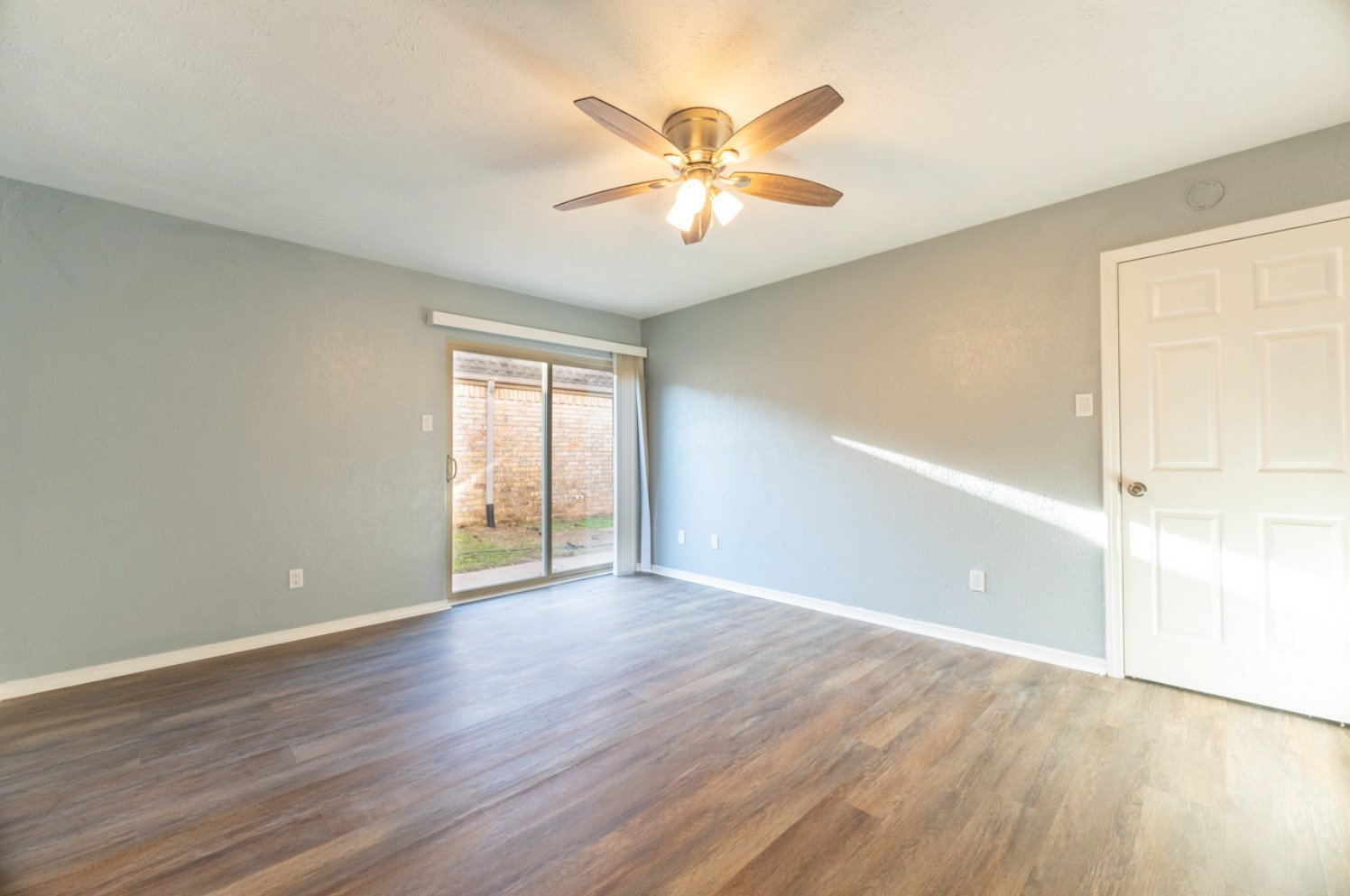 11803 Brook Meadows Lane Meadows Place, TX 77477 - Photo 11 of 17 an empty room with wooden floor fan and windows