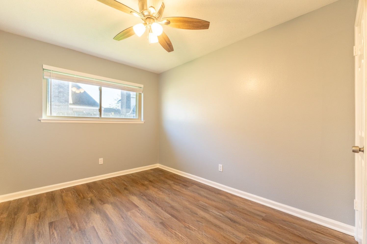 11803 Brook Meadows Lane Meadows Place, TX 77477 - Photo 14 of 17 an empty room with a window and wooden floor