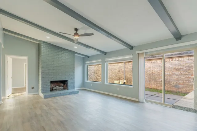 a view of an empty room with window and fire place