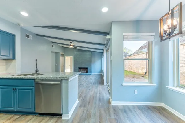 a kitchen with granite countertop a sink and wooden floor