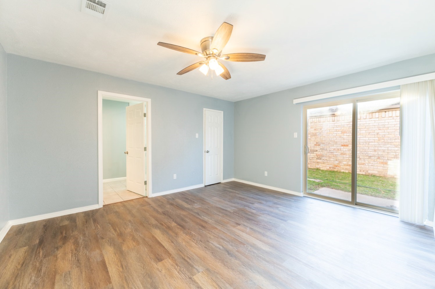 11803 Brook Meadows Lane Meadows Place, TX 77477 - Photo 7 of 17 a view of an empty room with wooden floor and a window