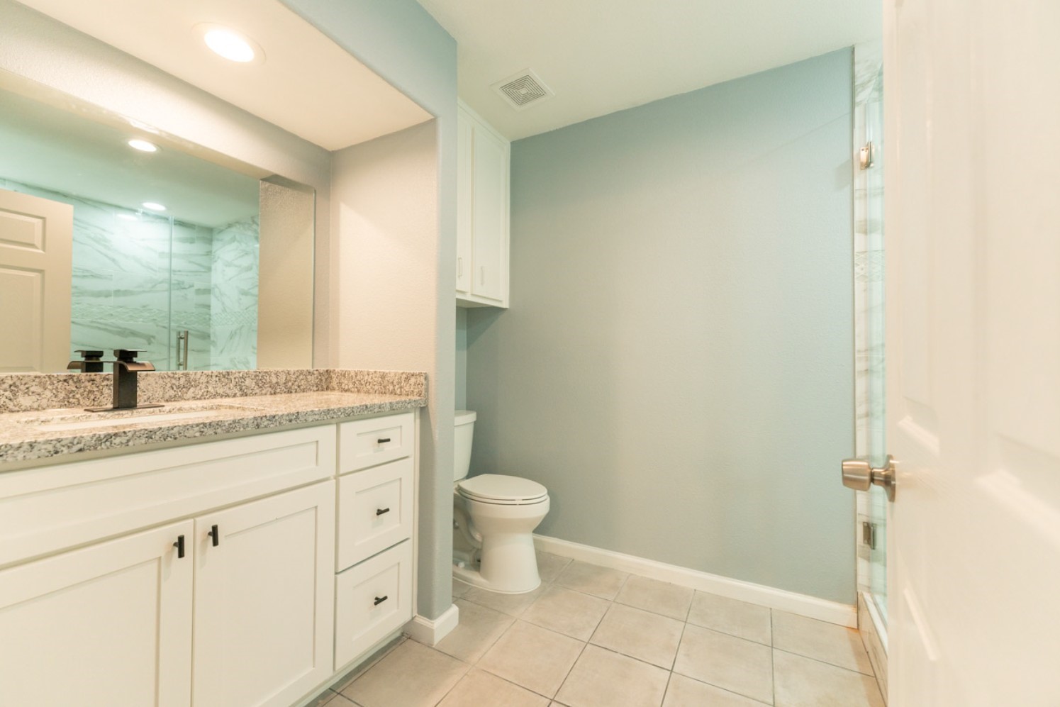 11803 Brook Meadows Lane Meadows Place, TX 77477 - Photo 9 of 17 a bathroom with a granite countertop sink a toilet and a mirror
