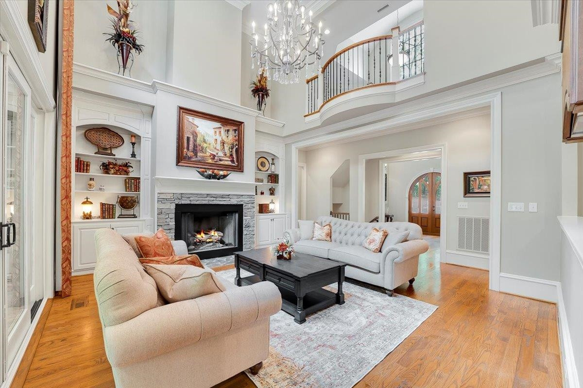 9712 Honeycutt Road Raleigh, NC 27614 - Photo 8 of 83 a living room with furniture a fireplace and a chandelier