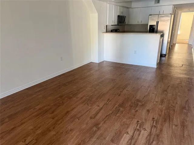 a view of a kitchen with wooden floor and a sink