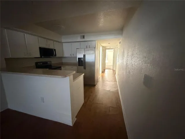 a kitchen with a refrigerator and a stove top oven