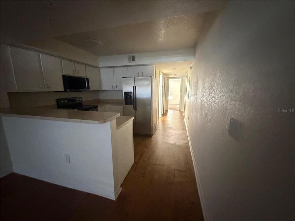 2323 McCoy Road, Unit 613 Orlando, FL 32809 - Photo 5 of 13 a kitchen with a refrigerator and a stove top oven