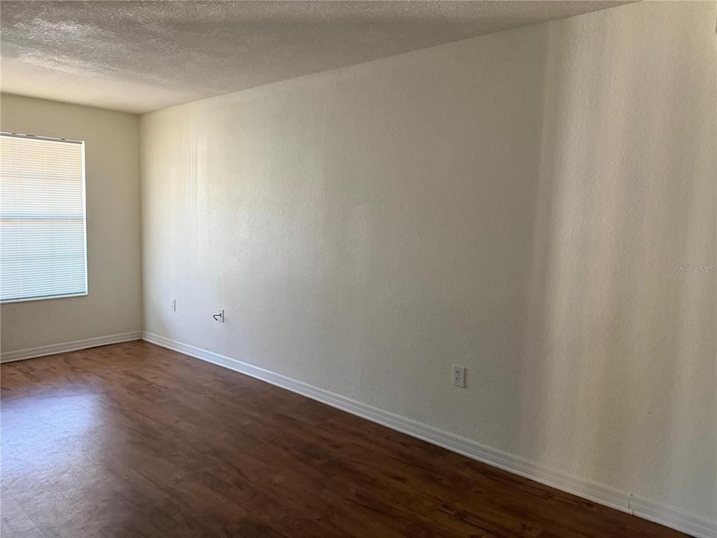 2323 McCoy Road, Unit 613 Orlando, FL 32809 - Photo 10 of 13 a view of an empty room with wooden floor and a window