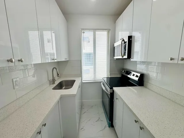 a kitchen with stainless steel appliances a sink a stove and refrigerator