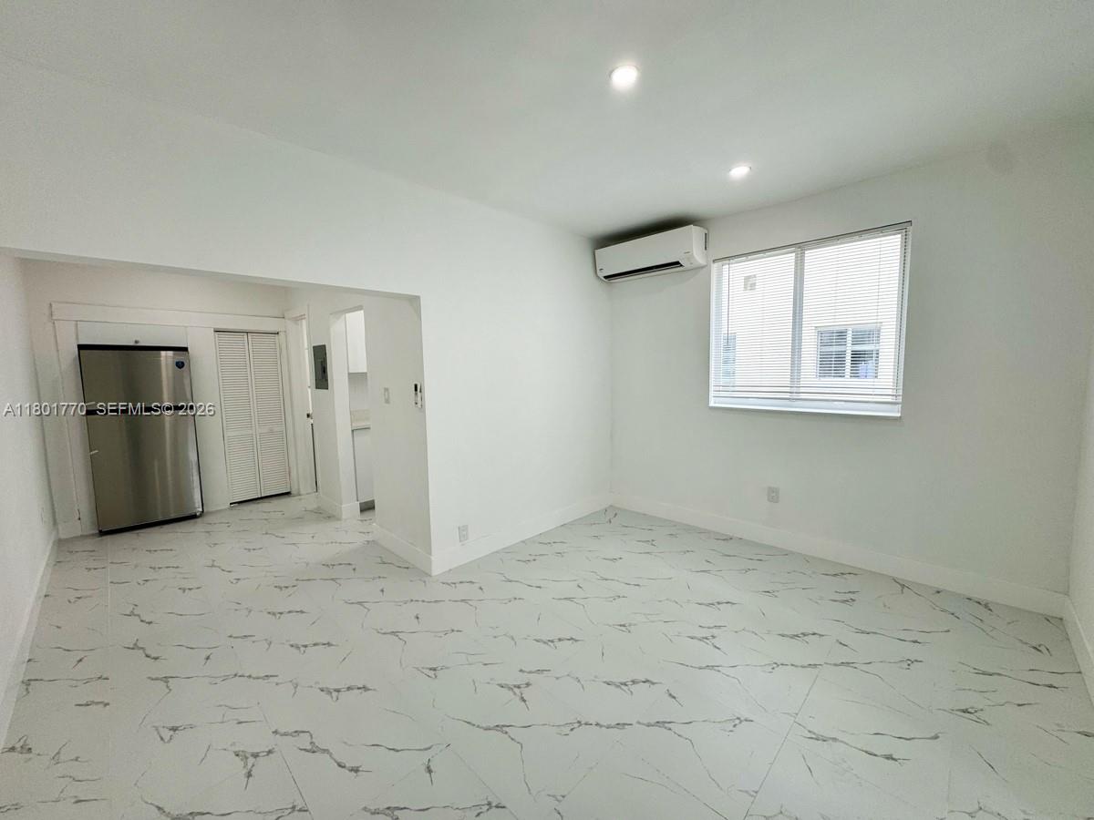 an empty room with closet and windows