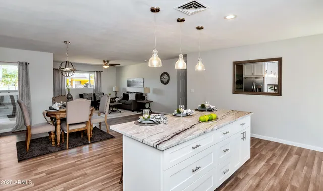 a living room with granite countertop furniture and a wooden floor