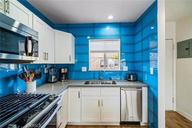 a kitchen that has a lot of cabinets in it and wooden floors