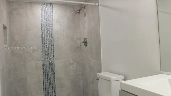 a bathroom with a shower a toilet and a sink