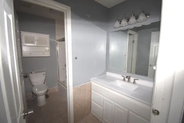 a bathroom with a sink a toilet and mirror