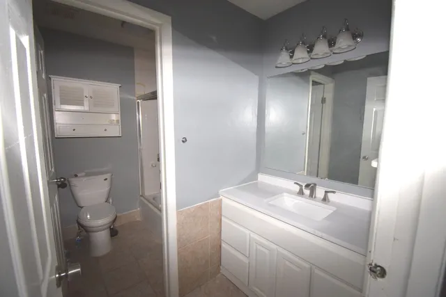 a bathroom with a sink a toilet and mirror