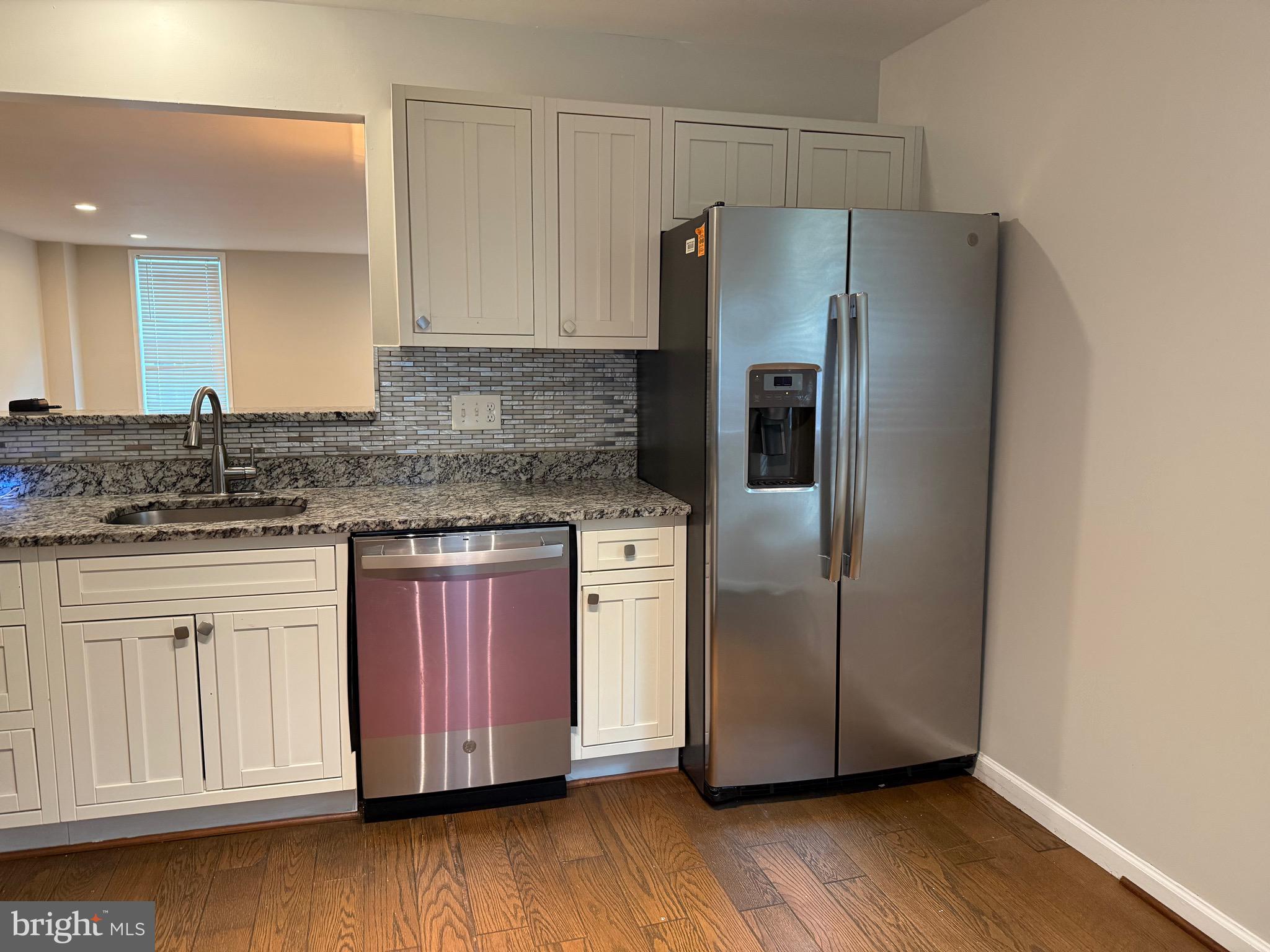 a kitchen with stainless steel appliances granite countertop a refrigerator and a stove