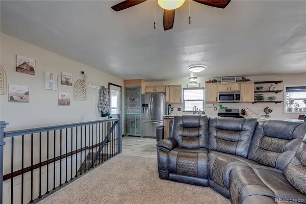 a living room with furniture kitchen view and a window