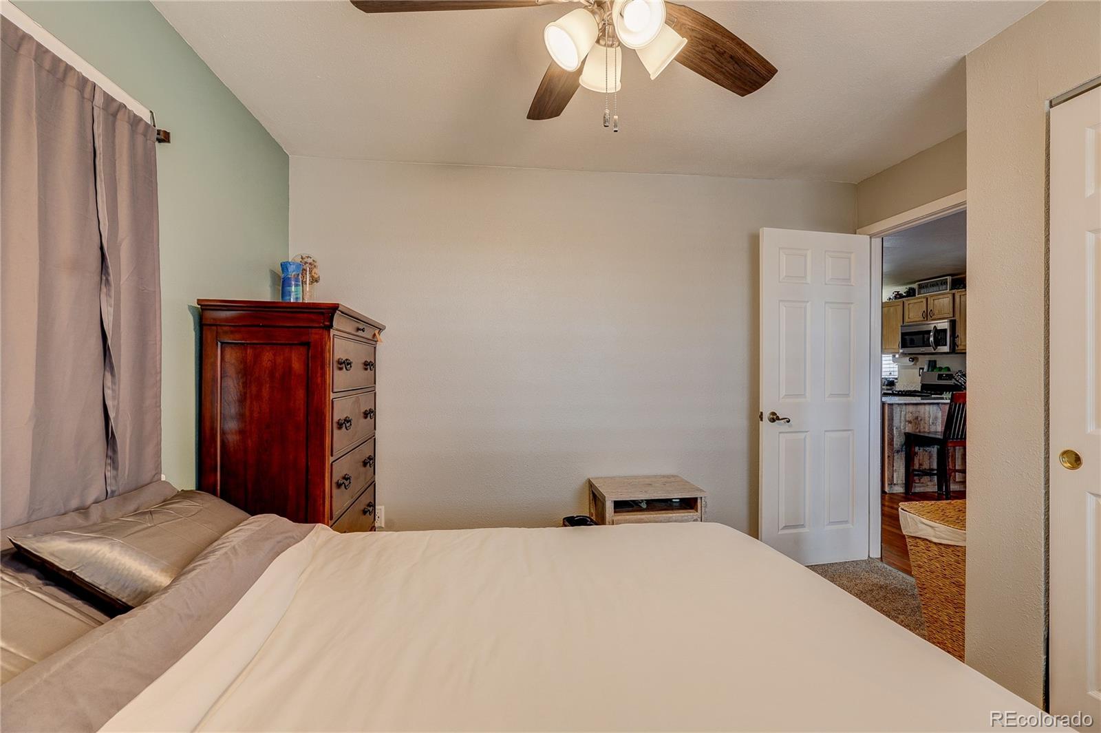 313 Front Street Roggen, CO 80652 - Photo 13 of 49 a bedroom with a bed and wooden floor