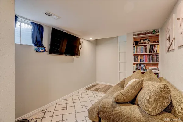 a living room with a bed furniture and a flat screen tv