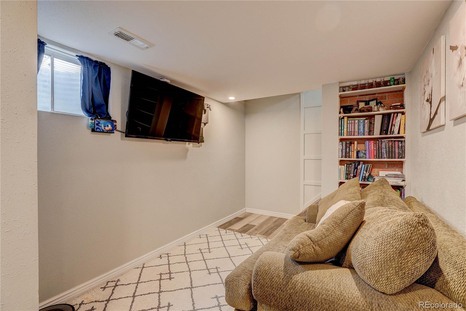 313 Front Street Roggen, CO 80652 - Photo 21 of 49 a living room with a bed furniture and a flat screen tv