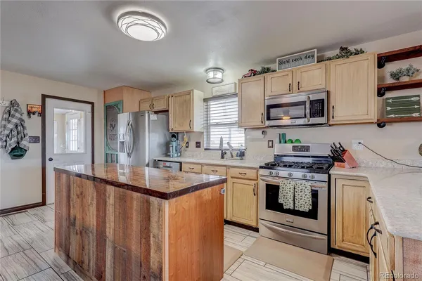 a kitchen with stainless steel appliances granite countertop a stove top oven a sink and a microwave