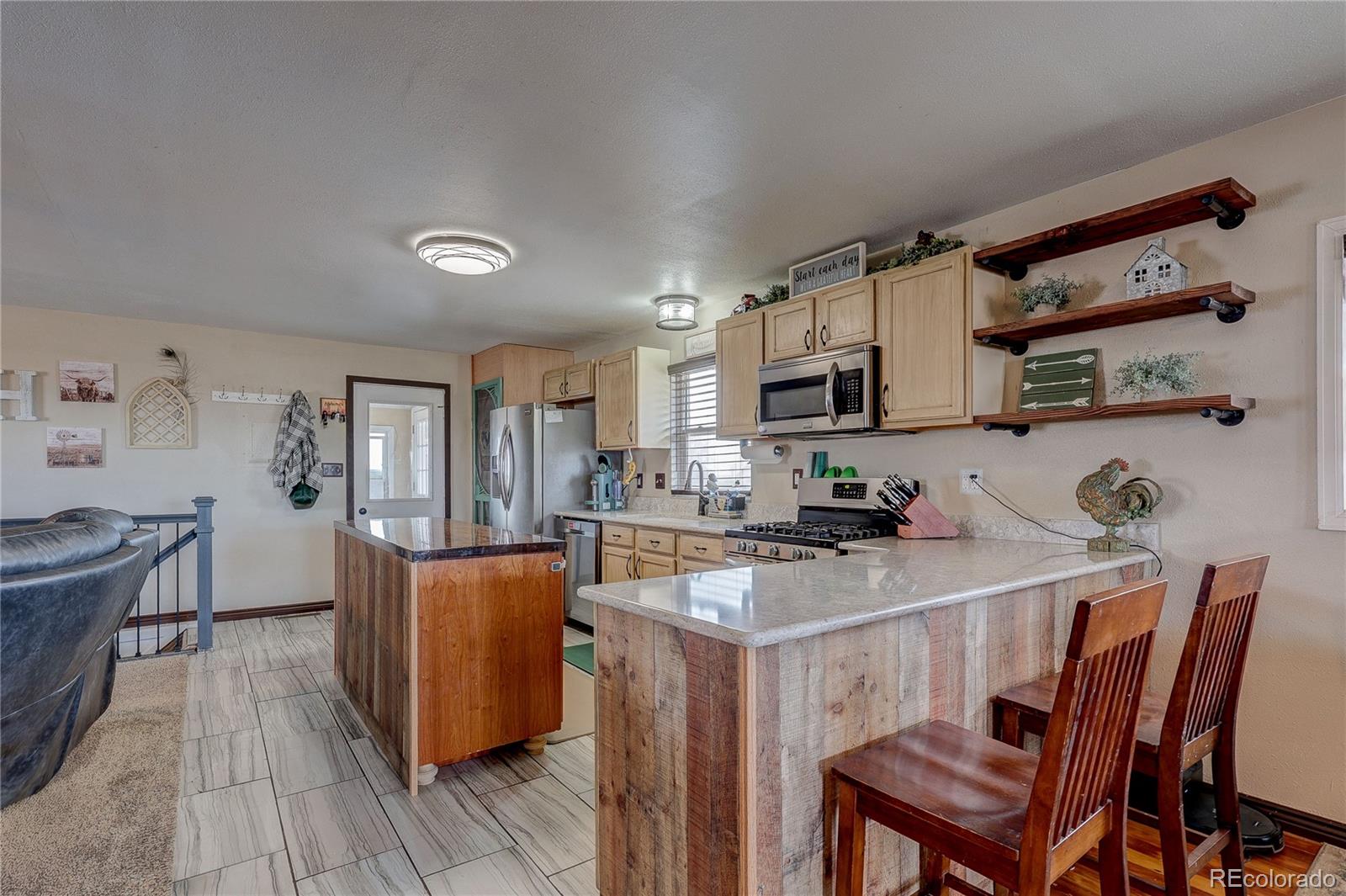313 Front Street Roggen, CO 80652 - Photo 7 of 49 a kitchen with stainless steel appliances a dining table and chairs in it