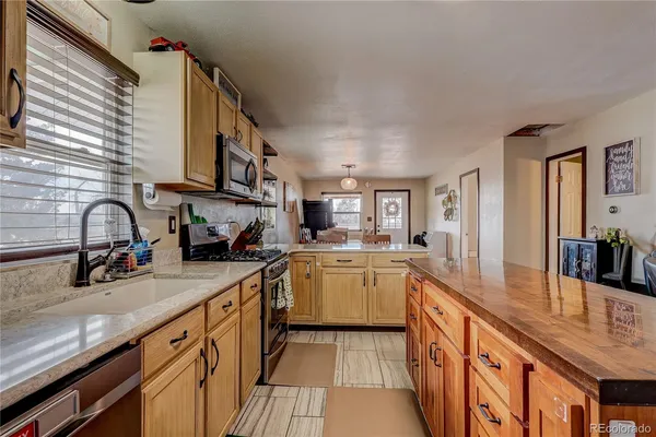 a kitchen with stainless steel appliances granite countertop a sink stove and cabinets