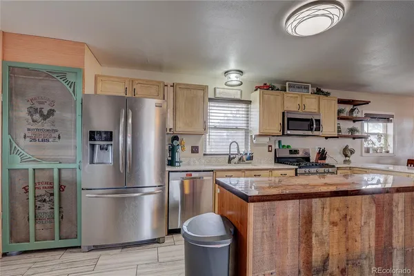 a kitchen with stainless steel appliances granite countertop a refrigerator sink and stove