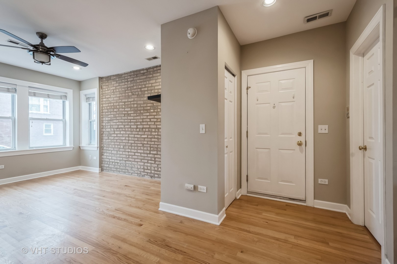 3337 West Byron Street, Unit 1 Chicago, IL 60618 - Photo 3 of 12 an empty room with wooden floor and a ceiling fan