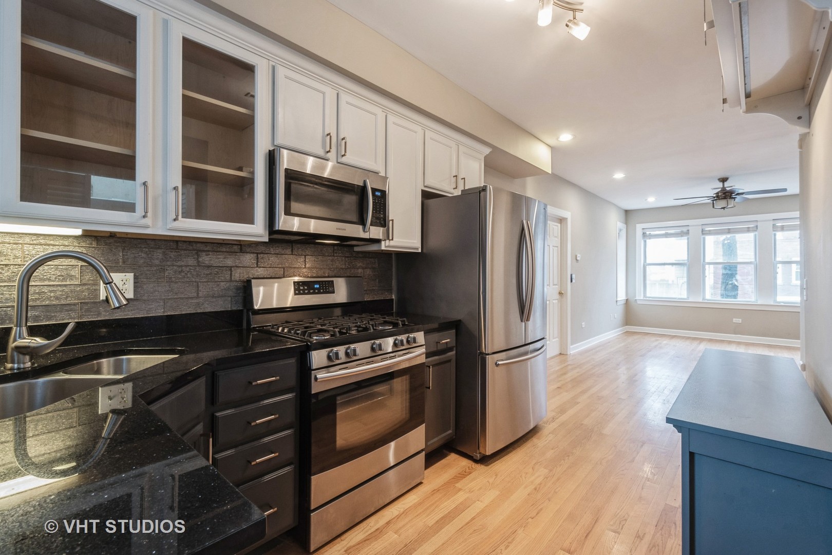 3337 West Byron Street, Unit 1 Chicago, IL 60618 - Photo 6 of 12 a kitchen with stainless steel appliances a stove a sink and a microwave