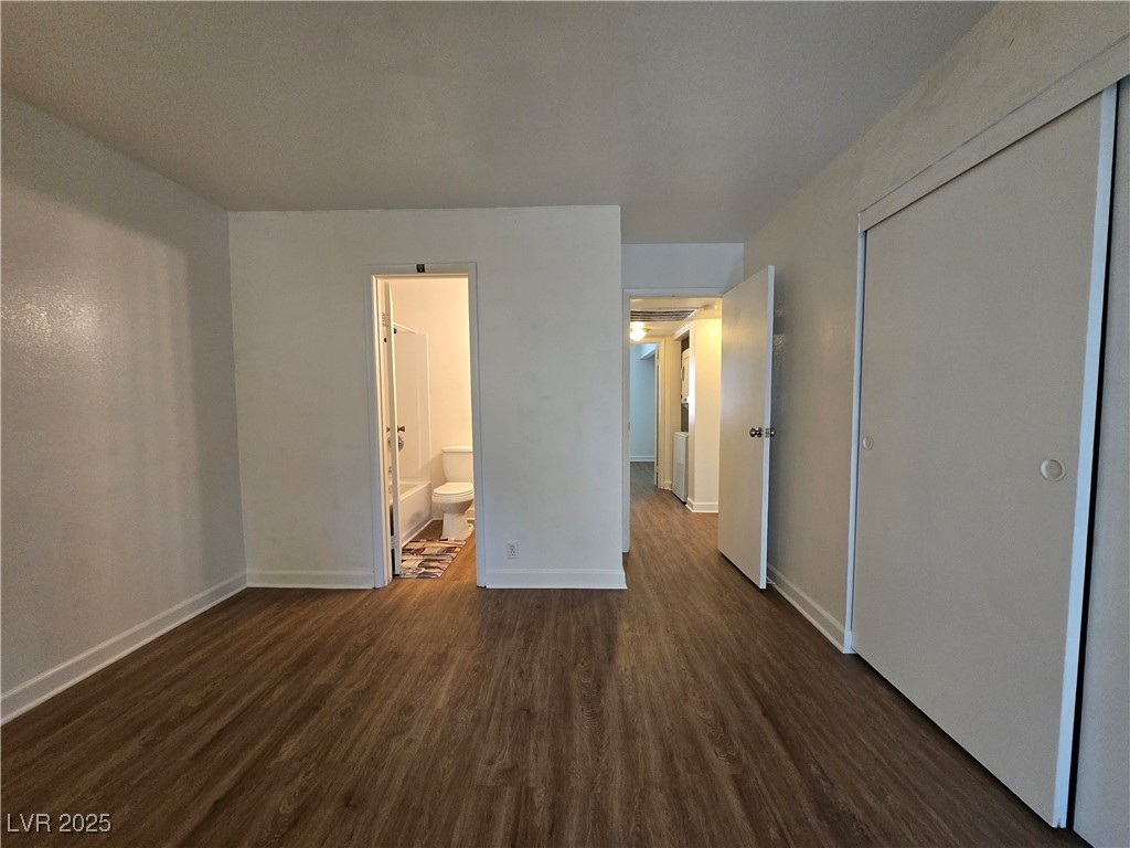 4440 Rich Drive, Unit C Las Vegas, NV 89102 - Photo 12 of 15 Unfurnished bedroom featuring dark wood-style floors, a closet, and connected bathroom