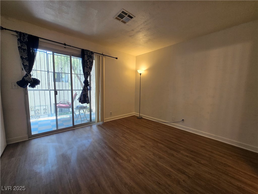 4440 Rich Drive, Unit C Las Vegas, NV 89102 - Photo 10 of 15 Unfurnished room featuring dark wood-style floors and a textured ceiling