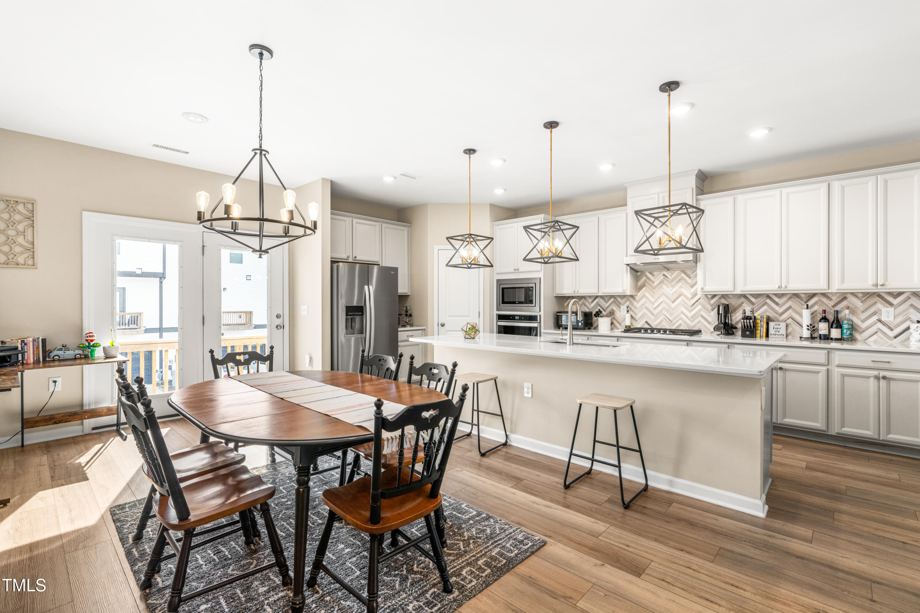 413 Diversity Way Raleigh, NC 27610 - Photo 10 of 50 a kitchen with stainless steel appliances a dining table chairs and white cabinets