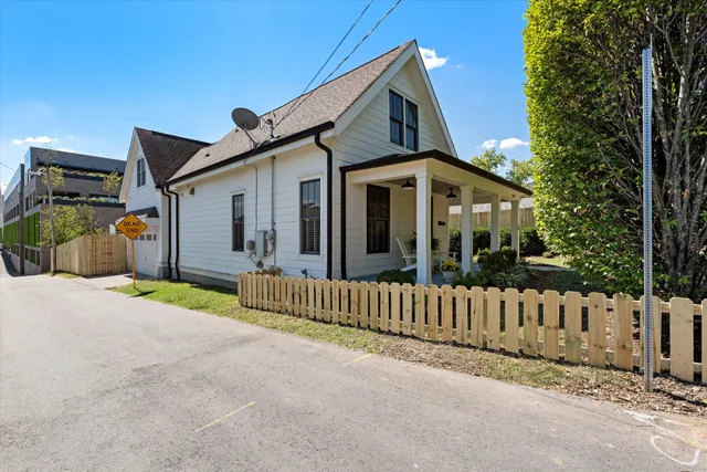 a porch with a table and chairs and potted plants