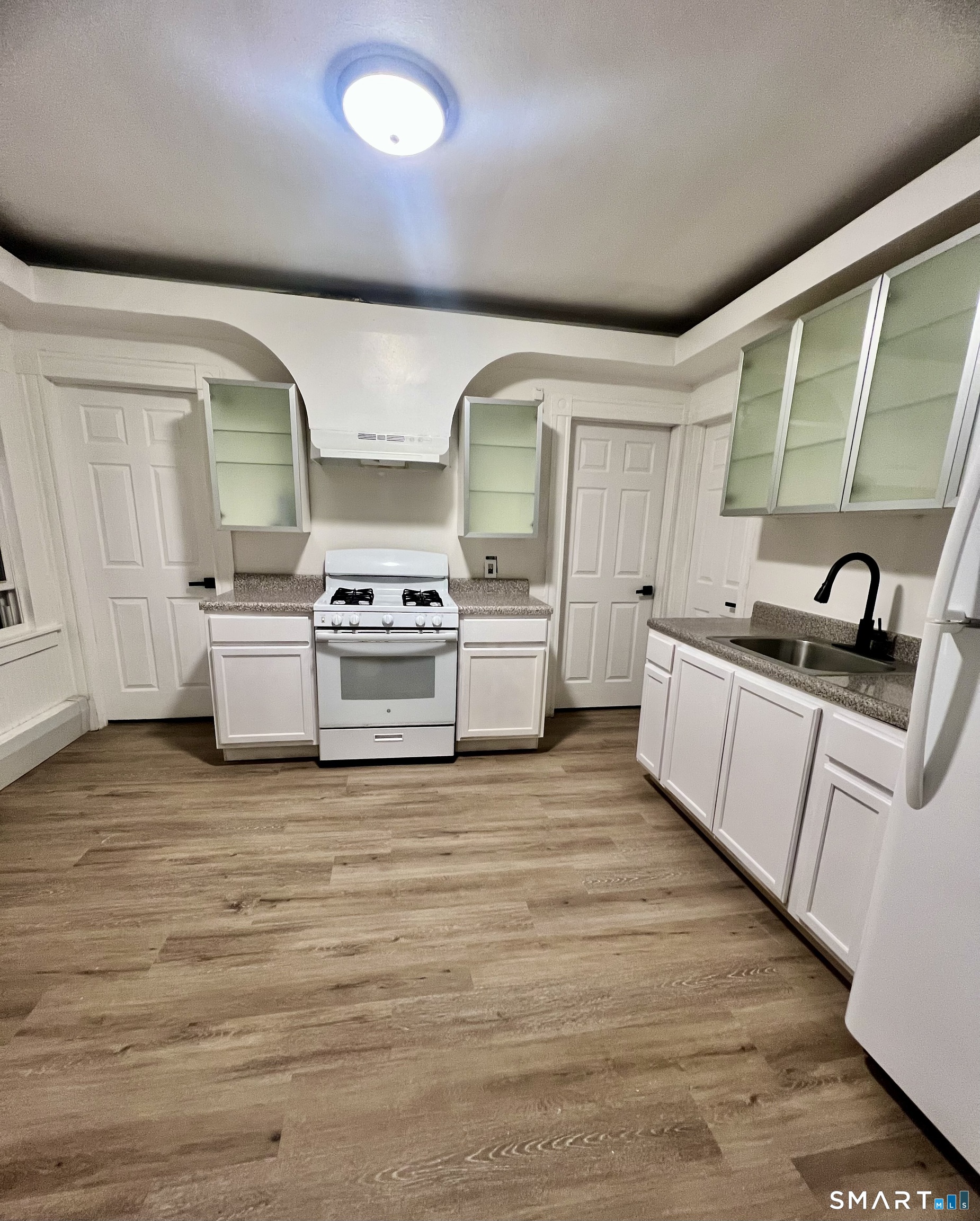 a kitchen with stainless steel appliances granite countertop a sink and stove top oven