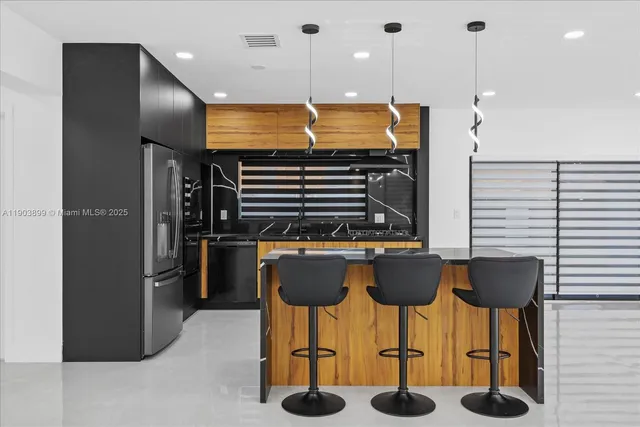a kitchen with granite countertop a refrigerator and a sink