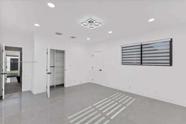 a view of a room with gym equipment and a chandelier