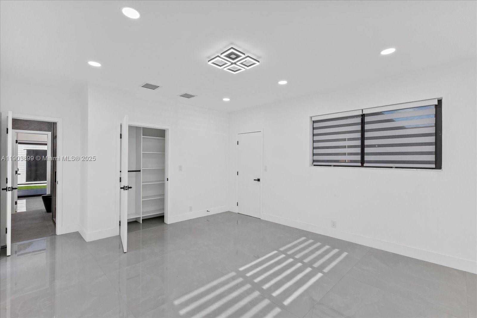 19511 Northeast 18th Place Miami, FL 33179 - Photo 21 of 38 an empty room with windows and closet