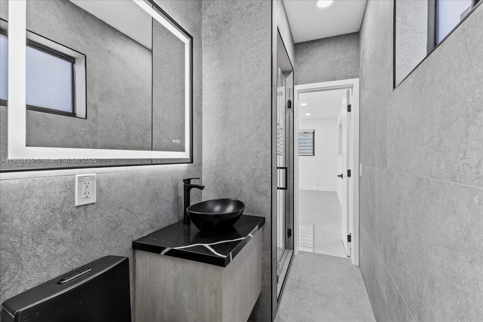 19511 Northeast 18th Place Miami, FL 33179 - Photo 23 of 38 a bathroom with a sink and a mirror