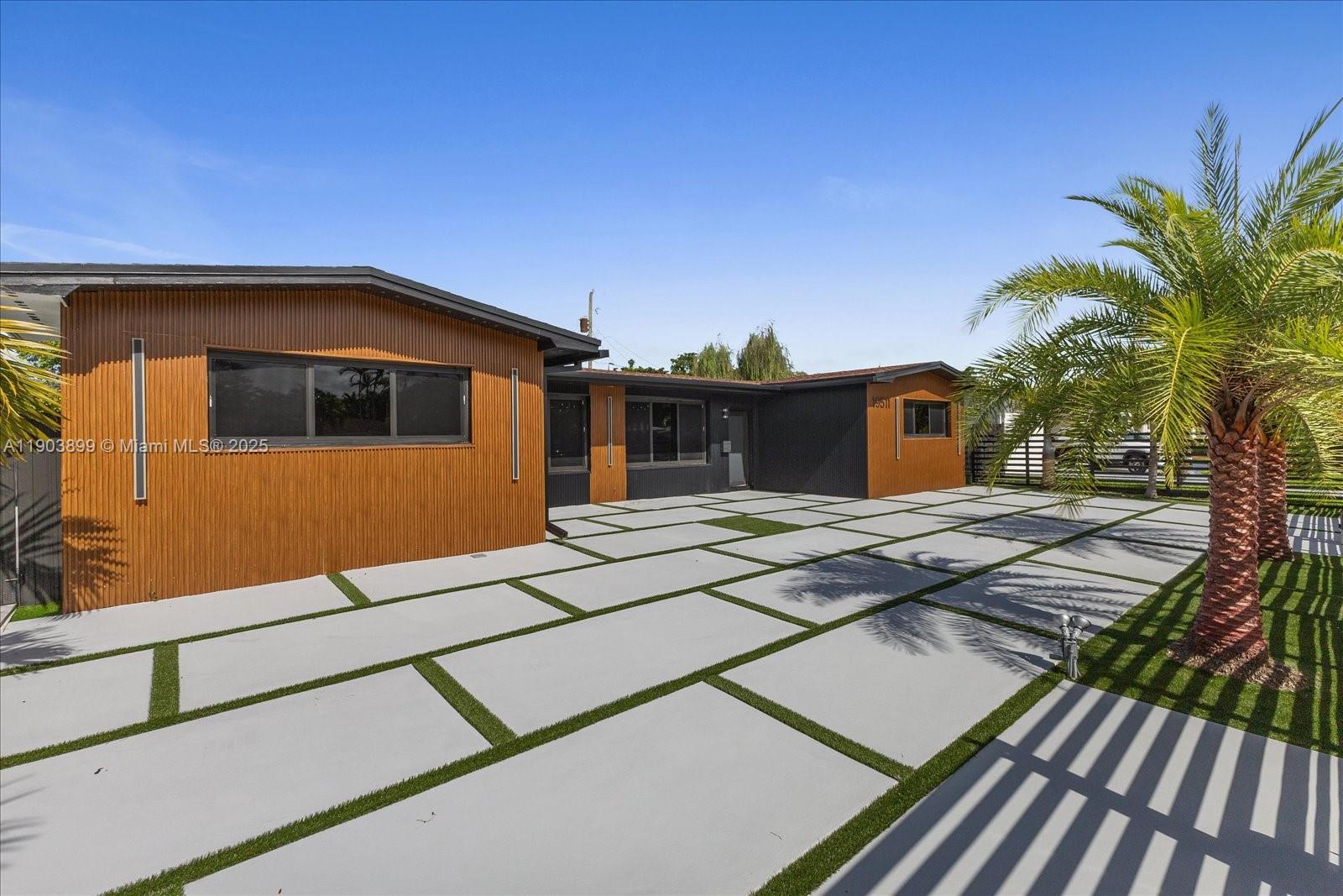 19511 Northeast 18th Place Miami, FL 33179 - Photo 5 of 38 a front view of a house with a yard