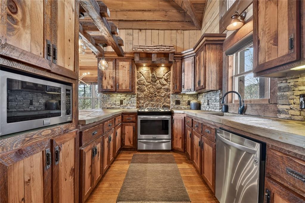 249 Settlement Road Epworth, GA 30541 - Photo 23 of 74 a kitchen with stainless steel appliances granite countertop a stove and cabinets