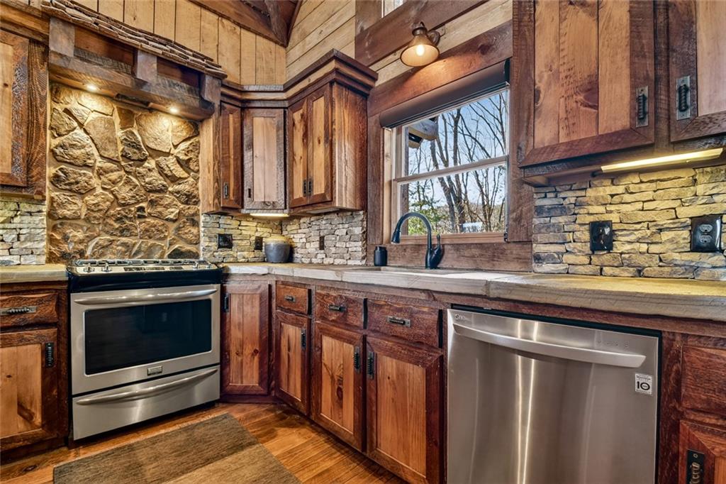 249 Settlement Road Epworth, GA 30541 - Photo 24 of 74 a kitchen with stainless steel appliances granite countertop a stove and a sink