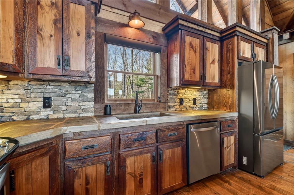 249 Settlement Road Epworth, GA 30541 - Photo 27 of 74 a kitchen with stainless steel appliances granite countertop a sink a stove and cabinets