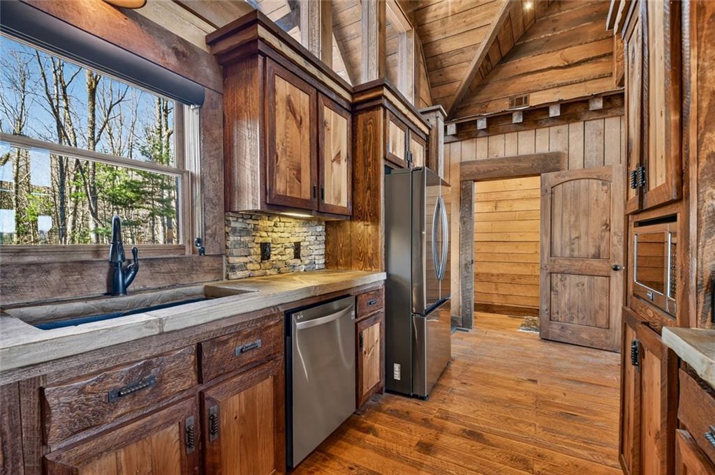249 Settlement Road Epworth, GA 30541 - Photo 28 of 74 a kitchen with stainless steel appliances granite countertop a refrigerator a sink and wooden floors