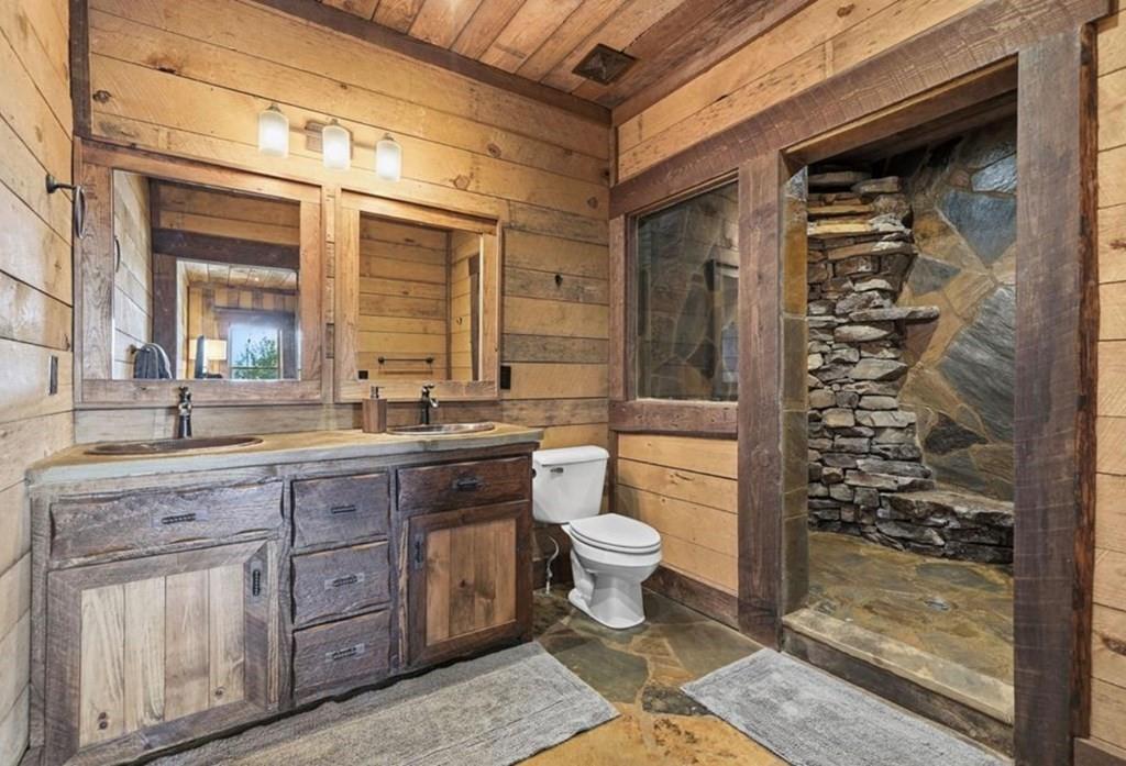 249 Settlement Road Epworth, GA 30541 - Photo 34 of 74 a bathroom with a granite countertop sink a toilet a mirror and shower