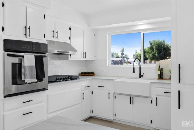 a kitchen with white cabinets and white appliances