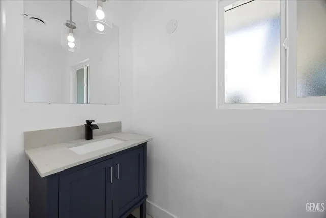 a bathroom with a sink vanity and a mirror